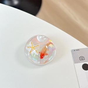 Detail of a transparent resin phone grip with lifelike red koi fish and white starfish