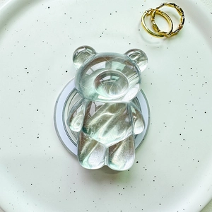 Macro detail of transparent bear phone grip featuring internal silver brushed texture