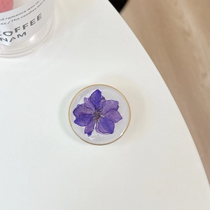 Macro detail of round phone socket featuring real purple flower and golden edge