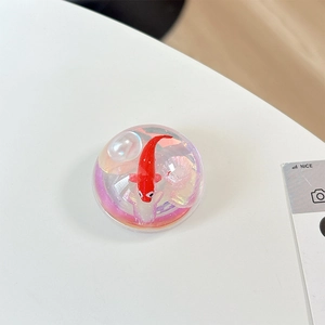 Detail of round phone socket with red koi fish, pearls, and holographic shell textures