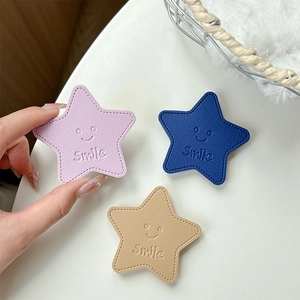 Star-shaped leather folding phone grip set in pink, navy, and khaki with smile logo