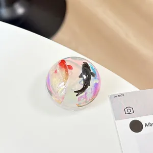 Macro shot of 3D koi fish resin phone grip with colorful iridescent sparkling base