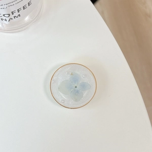 Close-up of handmade resin phone grip featuring blue dried flower and mini pearls