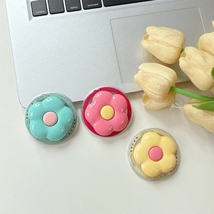 Floral SPU Magsafe phone grips in mint green and pink on a laptop desk setup