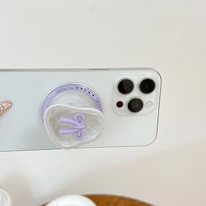Gros plan d'un support MagSafe avec nœud papillon violet 3D et texte Gift For You sur iPhone