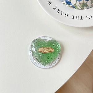 Macro shot of green heart phone grip with silver flakes and gold nicemood metal plate