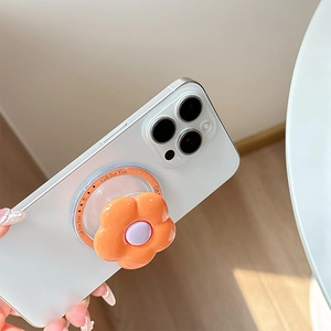 Macro shot of an orange flower phone grip with Gift For You text on a white smartphone