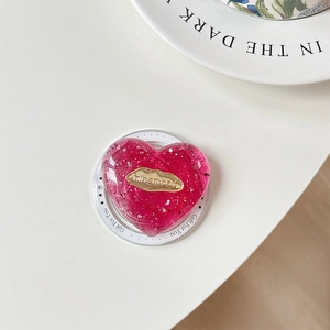 Macro shot of pink glitter heart phone grip with gold metallic engraved nameplate
