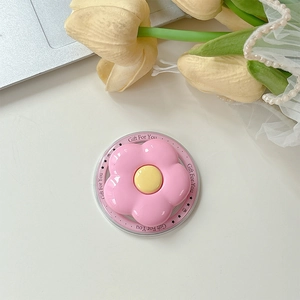 Pink flower Griptok phone stand with a transparent base on a cozy floral tabletop