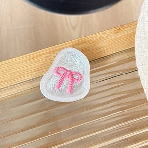 Détail d'un support de téléphone perlé avec un design de nœud papillon rose 3D