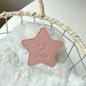 Close-up of pink star-shaped leather phone socket with stitched edges and Smile embossing
