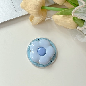 Detail of light blue floral MagSafe phone grip with Gift For You printed base on desk