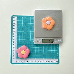 Detail showing flower phone grip diameter on a scale and weight of 17.2 grams