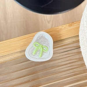 Détail d'un support de téléphone magnétique à nœud translucide sur surface en verre