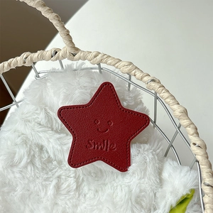 Close-up of red star-shaped leather phone grip with litchi texture and smile engraving