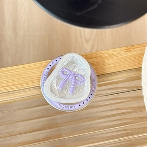 Détail macro du support magnétique avec nœud violet et base en nacre en forme de cœur