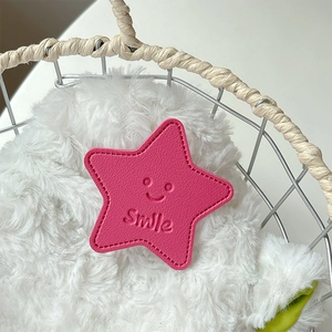 Close-up of pink leather star phone socket with a smile face and stitched edge