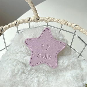 Macro detail of purple leather star phone grip with Smile embossing on soft plush surface