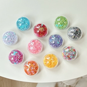 Colorful sequin ring DIY accessory set in 11 clear storage boxes on a white background