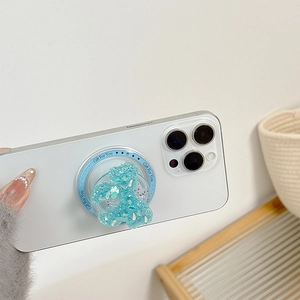 Close-up of a blue glitter bear foldable phone grip on a white smartphone device