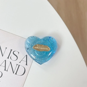 Dettaglio del supporto telefono a cuore blu con resina glitter e inserto in metallo