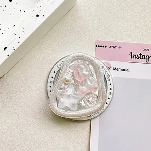 Detail of heart-shaped bear phone grip with stars and pearls on a textured background