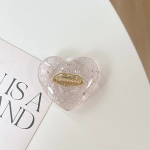 Dettaglio del supporto cuore rosa per telefono con glitter argento e placca oro