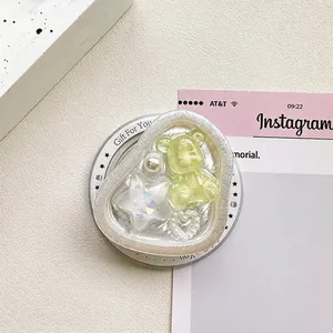Macro shot of bear and star charms inside a heart-shaped resin phone griptok holder