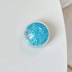 Macro shot of light blue holographic round sequins for DIY craft and nail art decoration