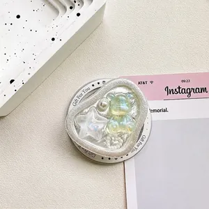 Close-up of heart-shaped phone grip with iridescent 3D bear, star, and pearl accents