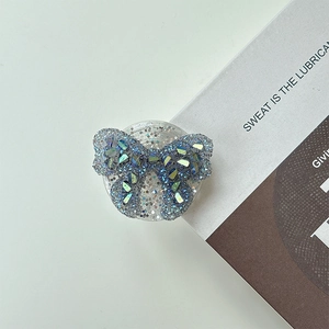 Detailed view of butterfly phone grip with sparkling blue crystals and glitter finish