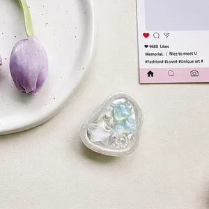 Detail of heart-shaped phone grip featuring a blue 3D bear star and pearls decor