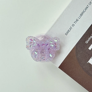 Close-up of a 3D purple glitter butterfly phone socket stand on a minimal white surface