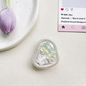 Detailed view of bear and star airbag phone stand with pearlescent finish