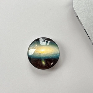 Close-up of a glossy crystal glass phone socket with a blue and gold galaxy star pattern