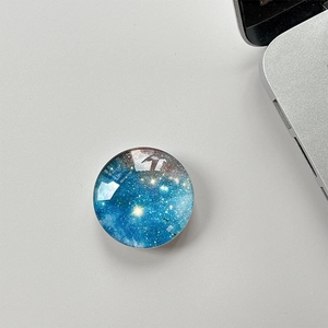 Macro view of blue galaxy pattern on round crystal glass phone socket stand
