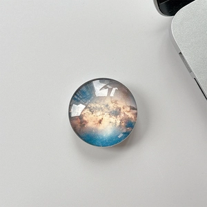 Top view of a crystal glass phone grip featuring a deep galaxy nebula star pattern
