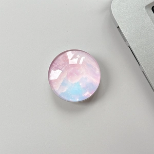Detailed top view of a round crystal glass phone grip with a pink and blue galaxy pattern
