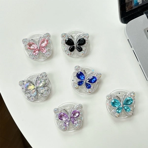 Eleganti supporti per telefono a farfalla con strass in vari colori su superficie bianca