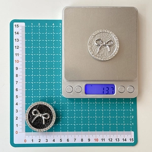 Detail showing bow phone grips with rhinestone edges measuring 3.8cm and 13.7g weight