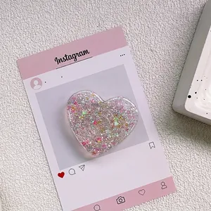 Détail d'un support de téléphone en forme de cœur avec paillettes roses et résine