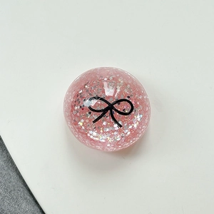 Detailed view of pink glitter phone socket featuring a minimalist black bow design