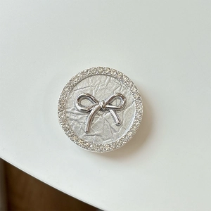 Silver bow phone grip with metallic foil texture and sparkling rhinestone outer ring