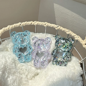 Support téléphone ours à paillettes avec miroir cœur sur surface en peluche