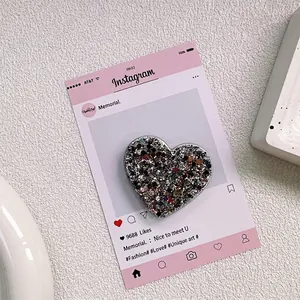Gros plan sur le support de téléphone en forme de cœur avec paillettes et finition résine