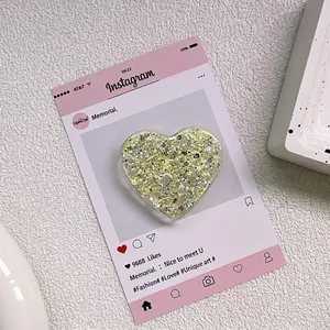 Gros plan d'un support de téléphone en forme de cœur avec paillettes dorées sur carte