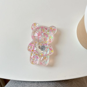 Détail du support de téléphone ours en résine avec paillettes et cœur argenté
