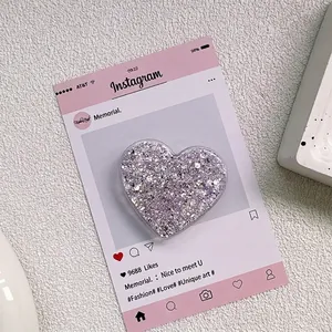 Détail du support de téléphone en forme de cœur avec paillettes violettes sur marbre