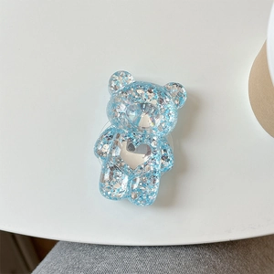 Détail d'un support de téléphone ours pailleté bleu clair avec miroir en forme de cœur