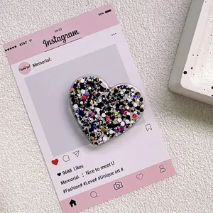 Vue détaillée du support téléphone en cœur avec paillettes colorées sous résine